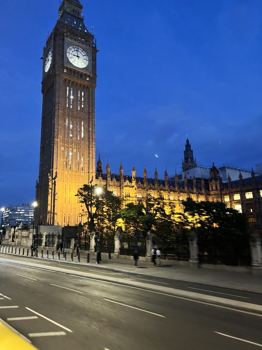 Big Ben illuminated at night against a deep blue sky.